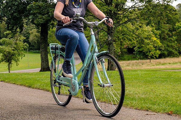 Green pendleton being ridden by a women in a park